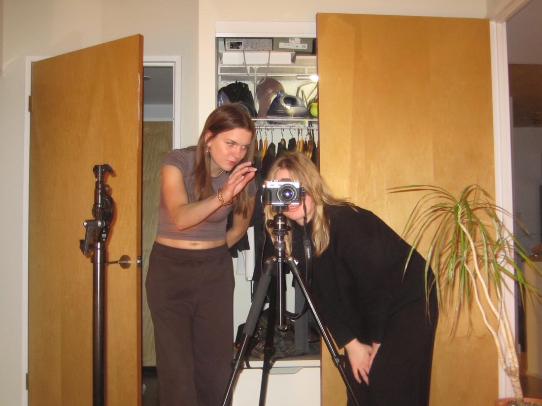 Anna setting up a shot on a camera tripod indoors