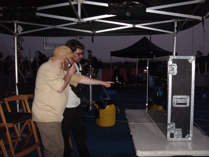 Two crew members talking under a canopy at a night shoot