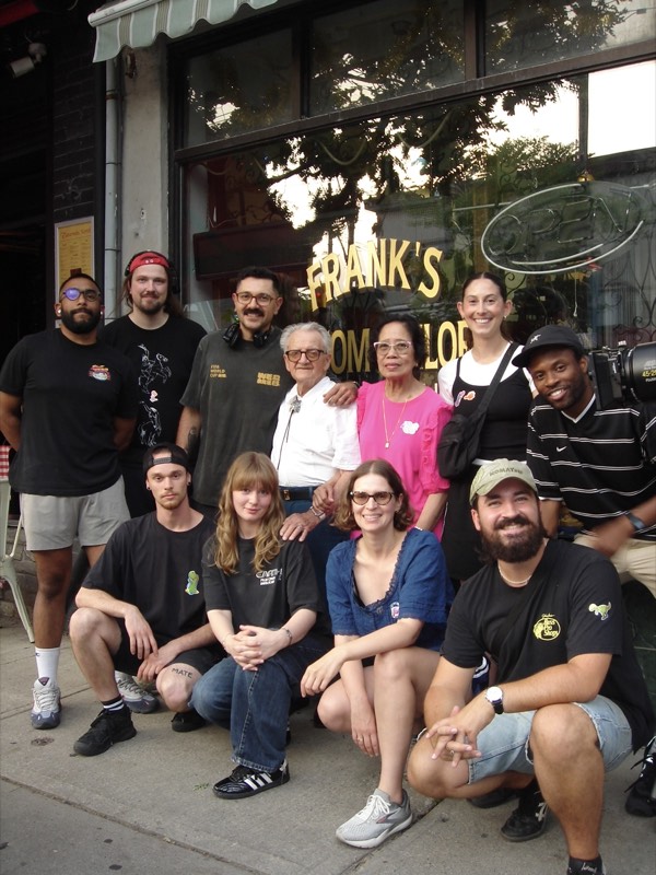 Crew group photo outside Frank's, the storefront sign visible behind